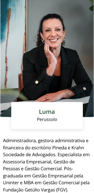 Uma mulher está sentada à mesa com a mão no queixo.